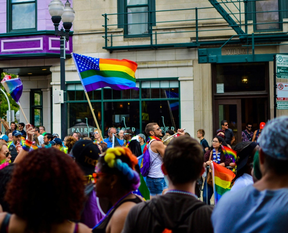 people hold the pride flag in the street
