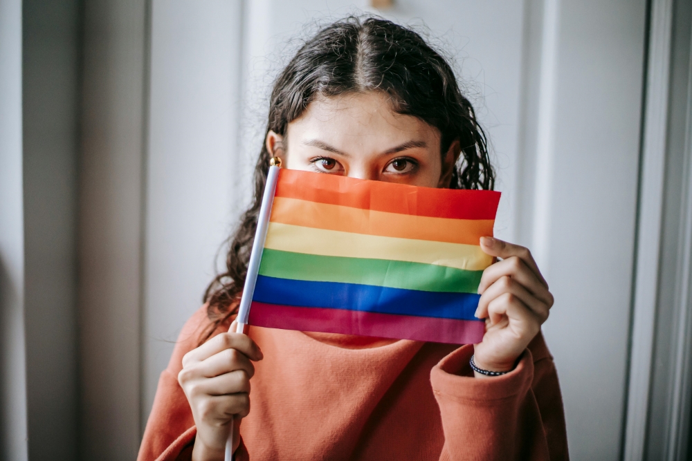 a girl show her support by holding a pride flag